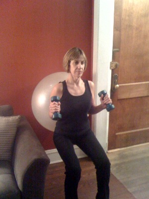 Mrs. Judy works out with a stability ball and dumbells
